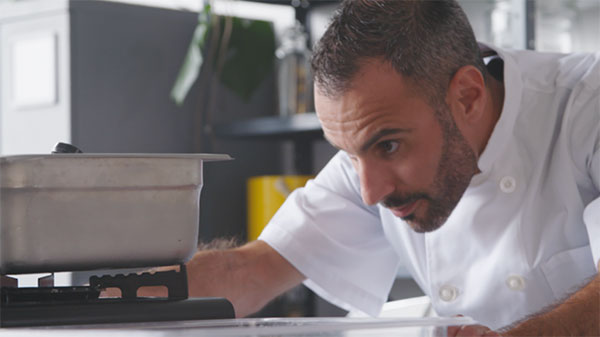 Man closely looking at flame on stove