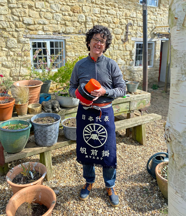 A woman holding cheese in a garden