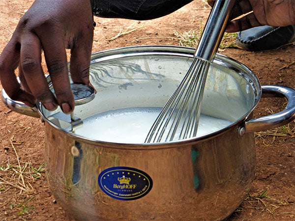 Mixing milk with a whisk in a metal pot