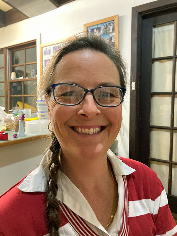 A woman smiling a cheese shop