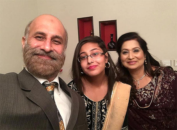 A family with a man and two women take a selfie for the camera