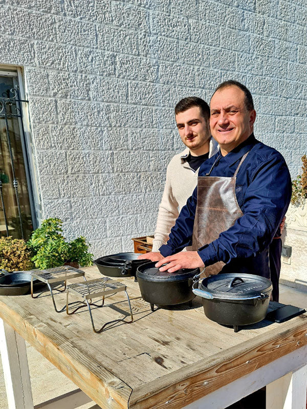 Two men with cookware making cheese