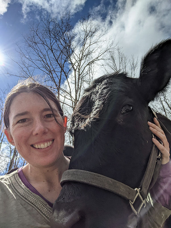 Woman smiling and petting her cow.